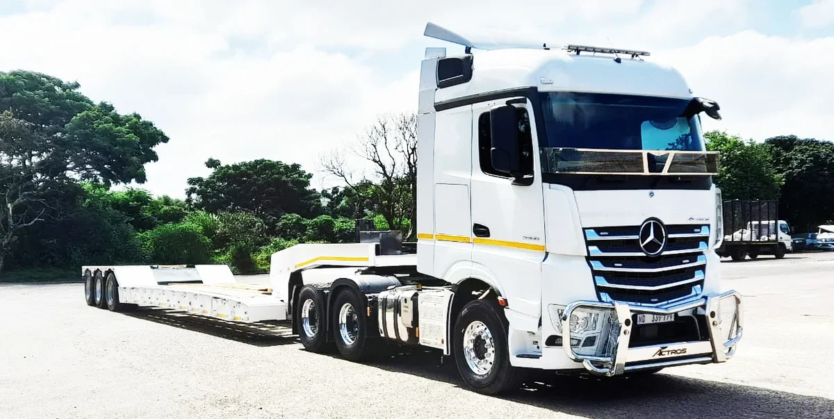 Unik Civil heavy transport truck carrying machinery on a public road project